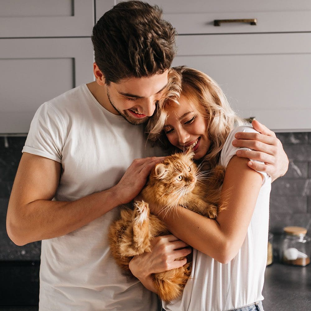 Happy Couple Holding Their Orange Cat